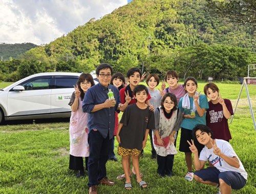 たのしさは島の端まで届くか? ―奥小学校エリアで〈こどもマルシェクッキング〉を開催・絶対安全レインボーは楽しんでもらえたか?@〈楽しい居場所&教育〉たのしい教育のエキスパート-子どもおひさまバザール-片づけまでがんばってくれた子どもたち先生たちと記念撮影